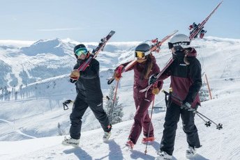 Gruppe von Skifahrern an einem sonnigen Wintertag auf dem Weg zum Lift in Gastein
