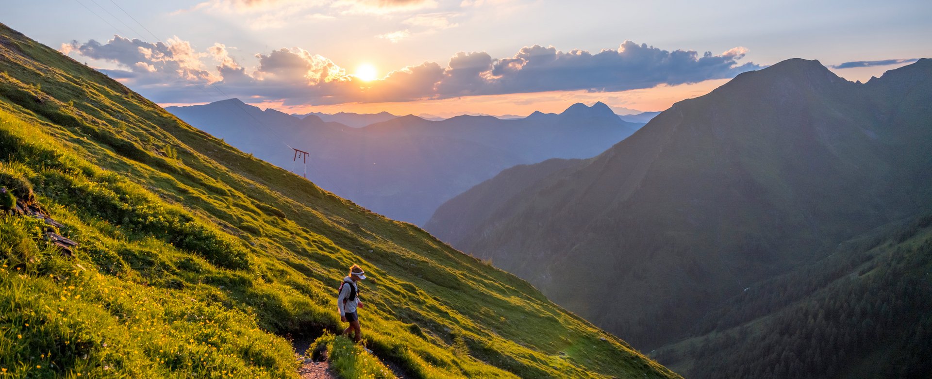 Trailrunner läuft bei Sonnenuntergang auf einem Bergpfad im Gasteinertal.
