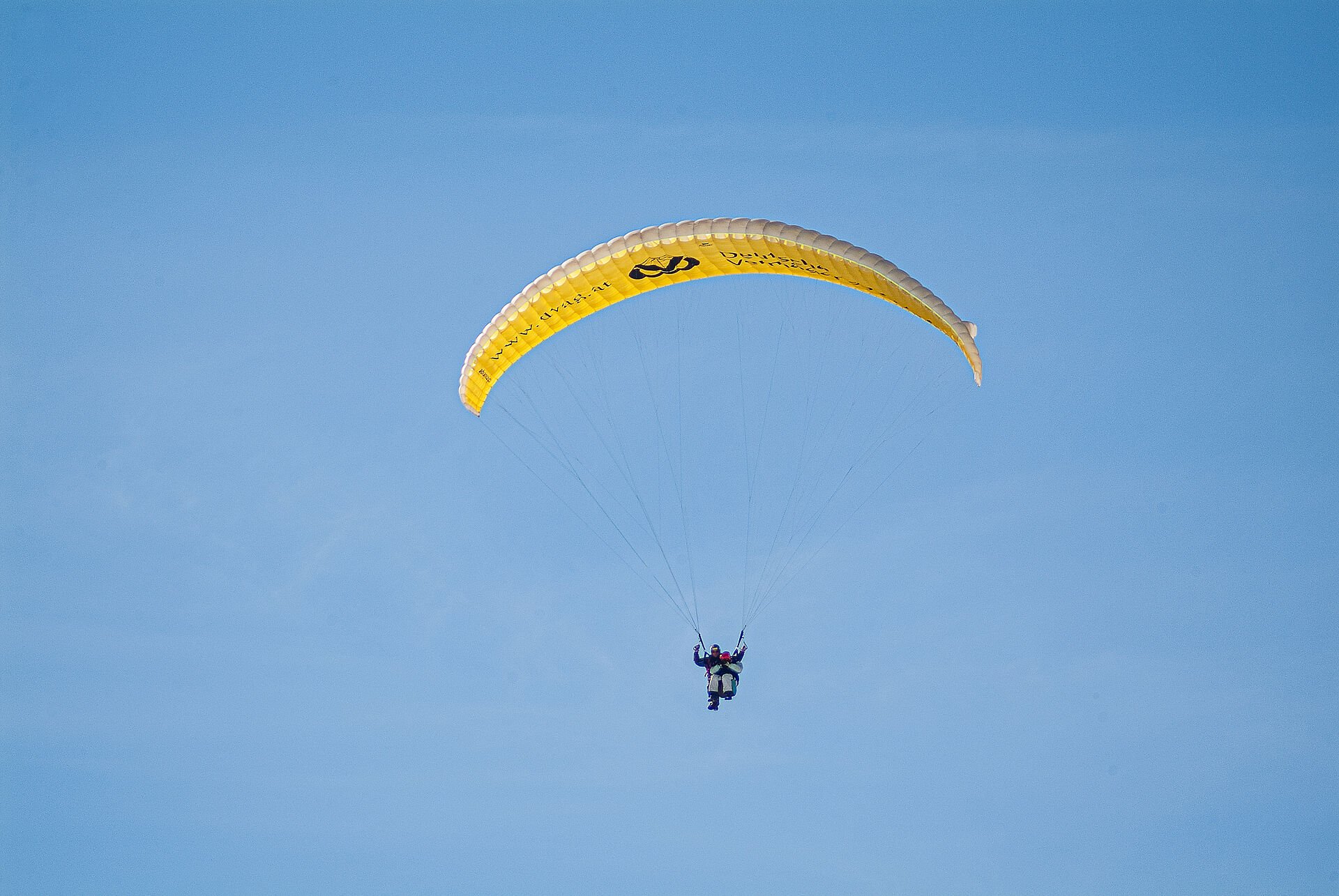 Paragleiter fliegt am Himmel über dem Gasteinertal.