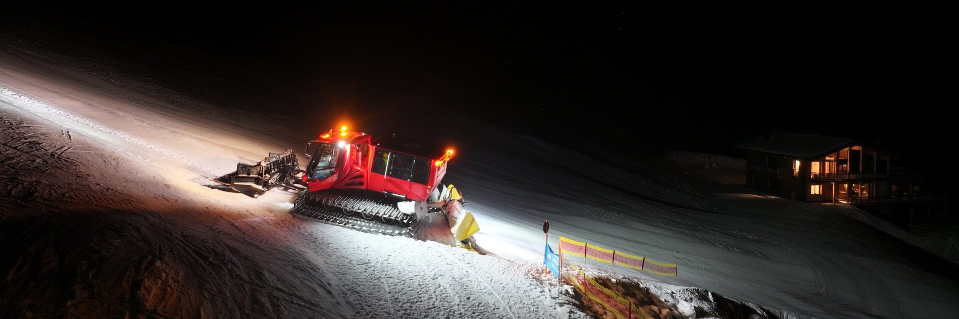 Der Pistenbully erleuchtet magisch die Piste