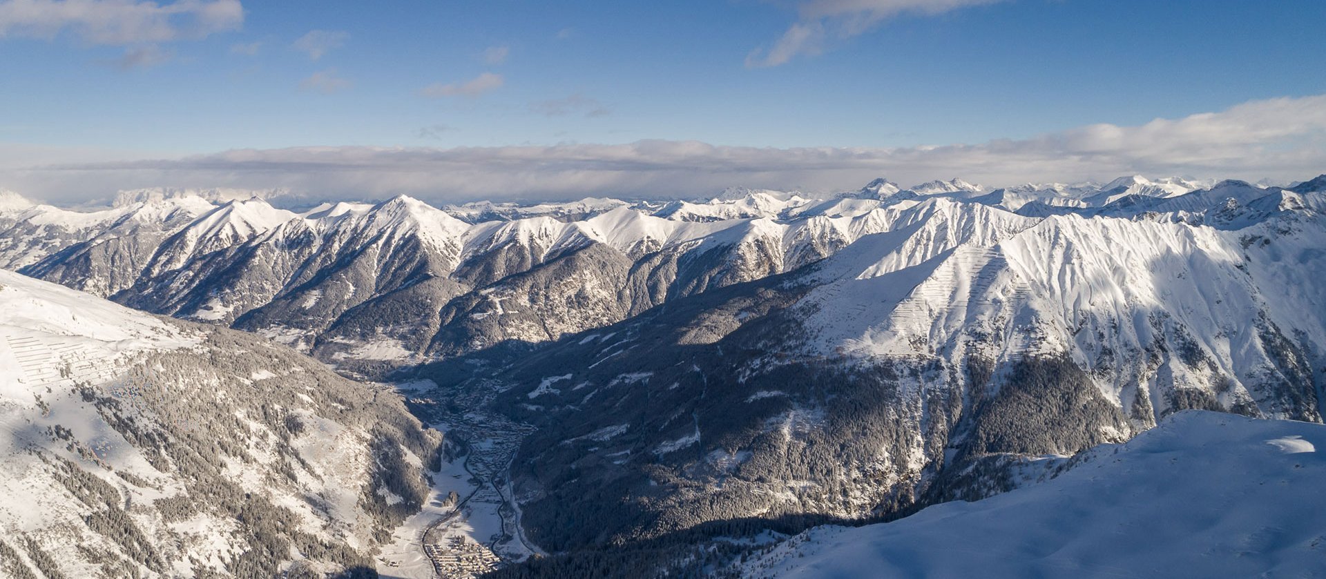 Das Gasteinertal aus Vogelperspektive mit verschneiten Bergspitzen 