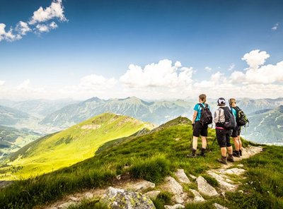 Drei Wanderer am Gipfel mit Blick über Gastein.