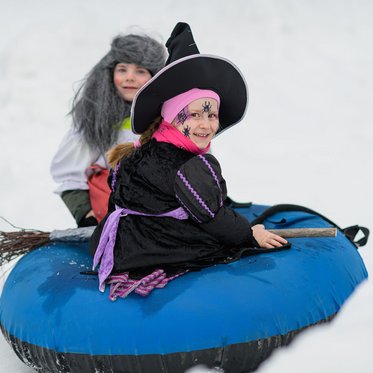 Kinder auf Snowtubing Reifen auf dem rauchleiten Übungshang
