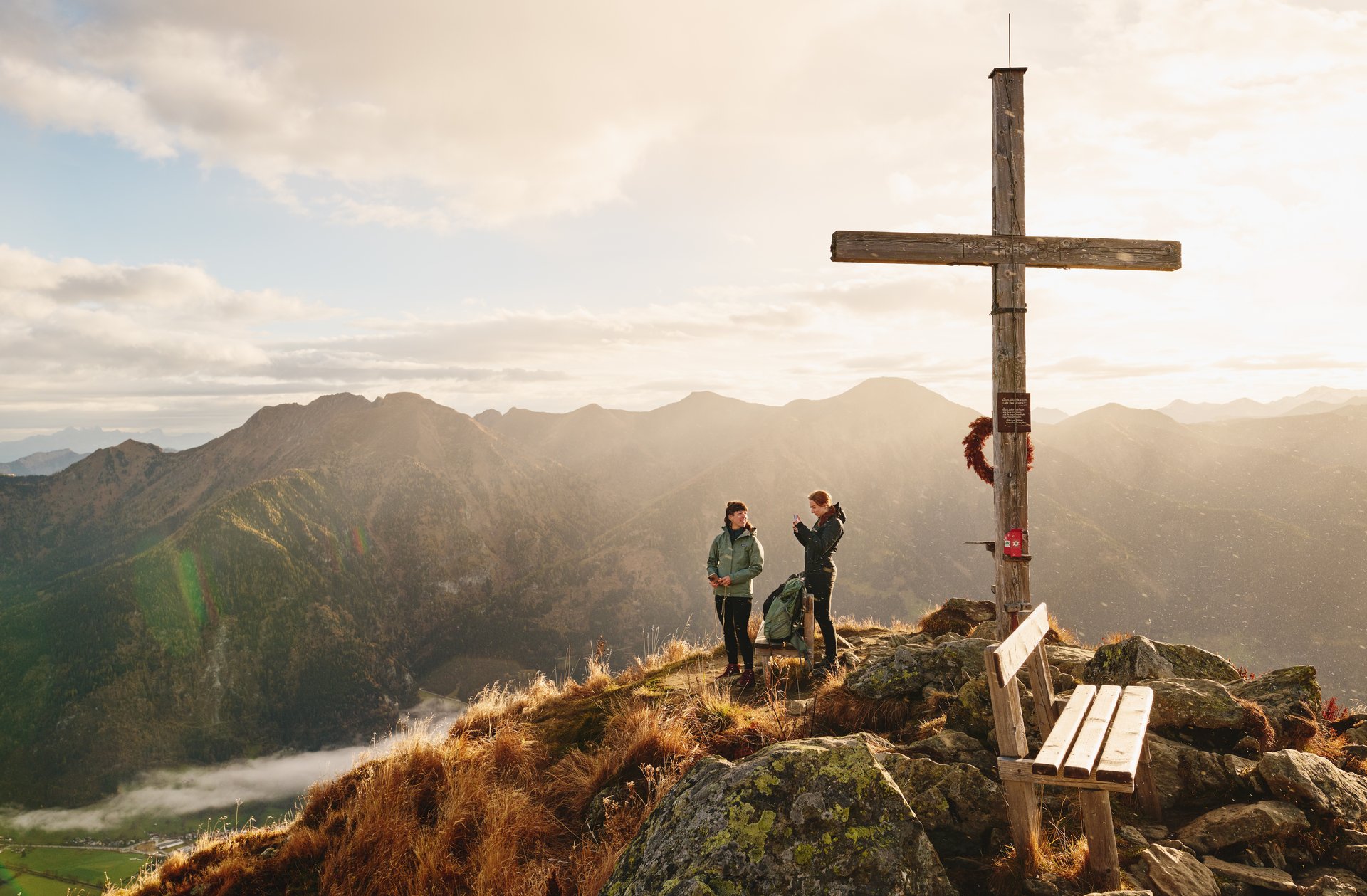 Aussichtsmoment am Gipfel mit Panorama über die Gasteiner Alpen im warmen Abendlicht.