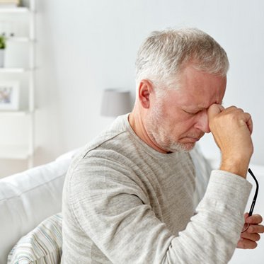 Mann greift sich an den Kopf