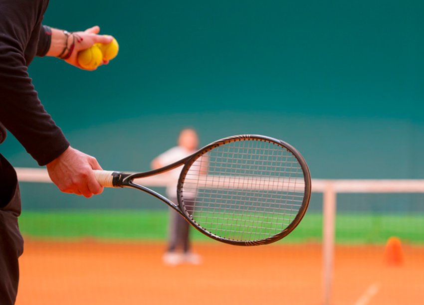 Tennisspieler schlägt einen Ball auf einem Tennisplatz.