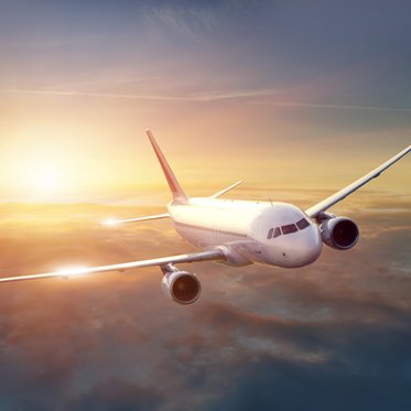 Flugzeug mit Sonnenuntergang im Hintergrund