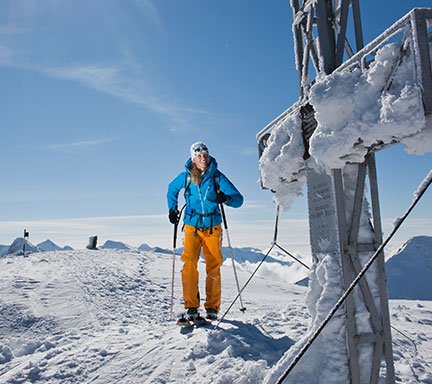 Ein Schitourengeher ist am Gipfel angekommen. Es nur mehr wenige Meter zum vereisten Gipfelkreuz in Gastein. Das Wetter ist perfekt. 