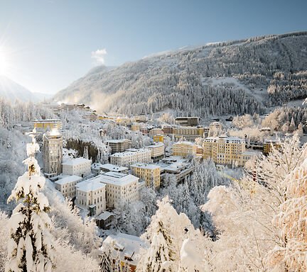 Bad Gastein in verschneiter Schneelandschaft mit Sonne, die hinter dem Berg untergeht