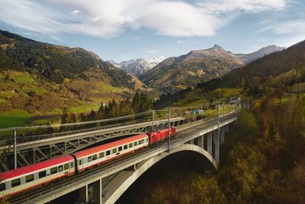 Zug fährt über eine Eisenbahnbrücke auf dem Weg in das Gasteinertal